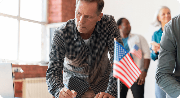 a man signing up with US flag beside