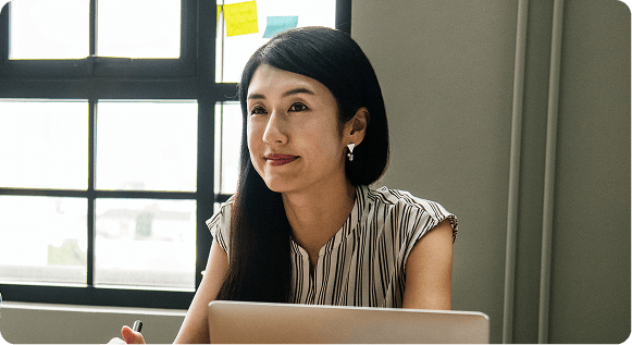 woman smiling if front of a laptop