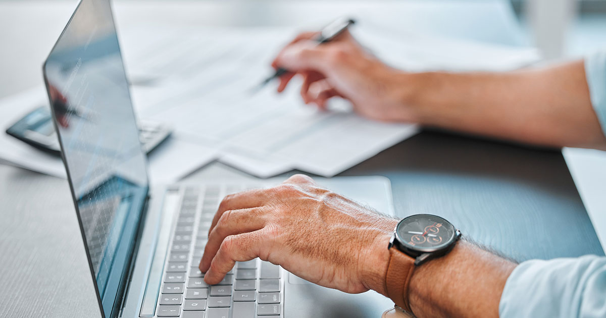Man with papers and a laptop